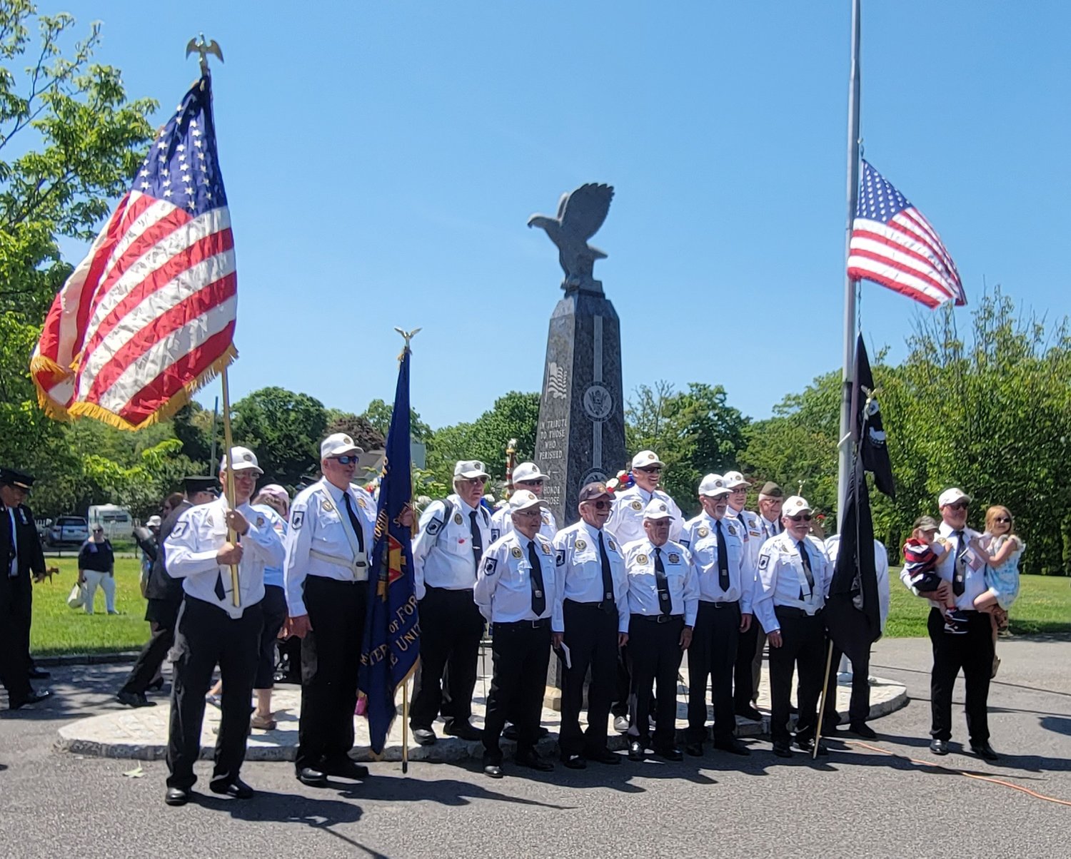 Veterans of Foreign Wars (VFW) 8300 stand in front of the monument commemorating fallen soldiers in Woodland Cemetery.